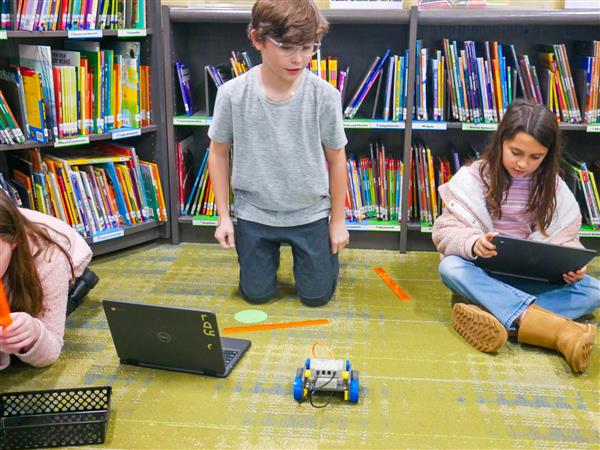 student with robot in library